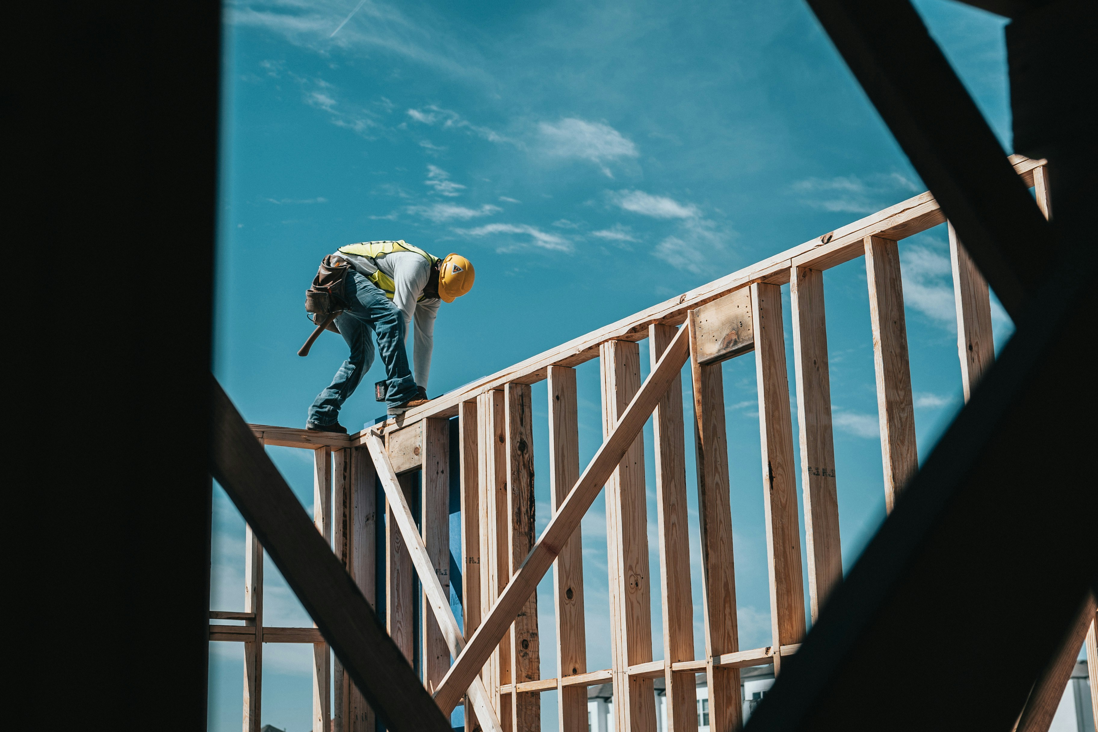 Framer working on top of a new wood-framed wall