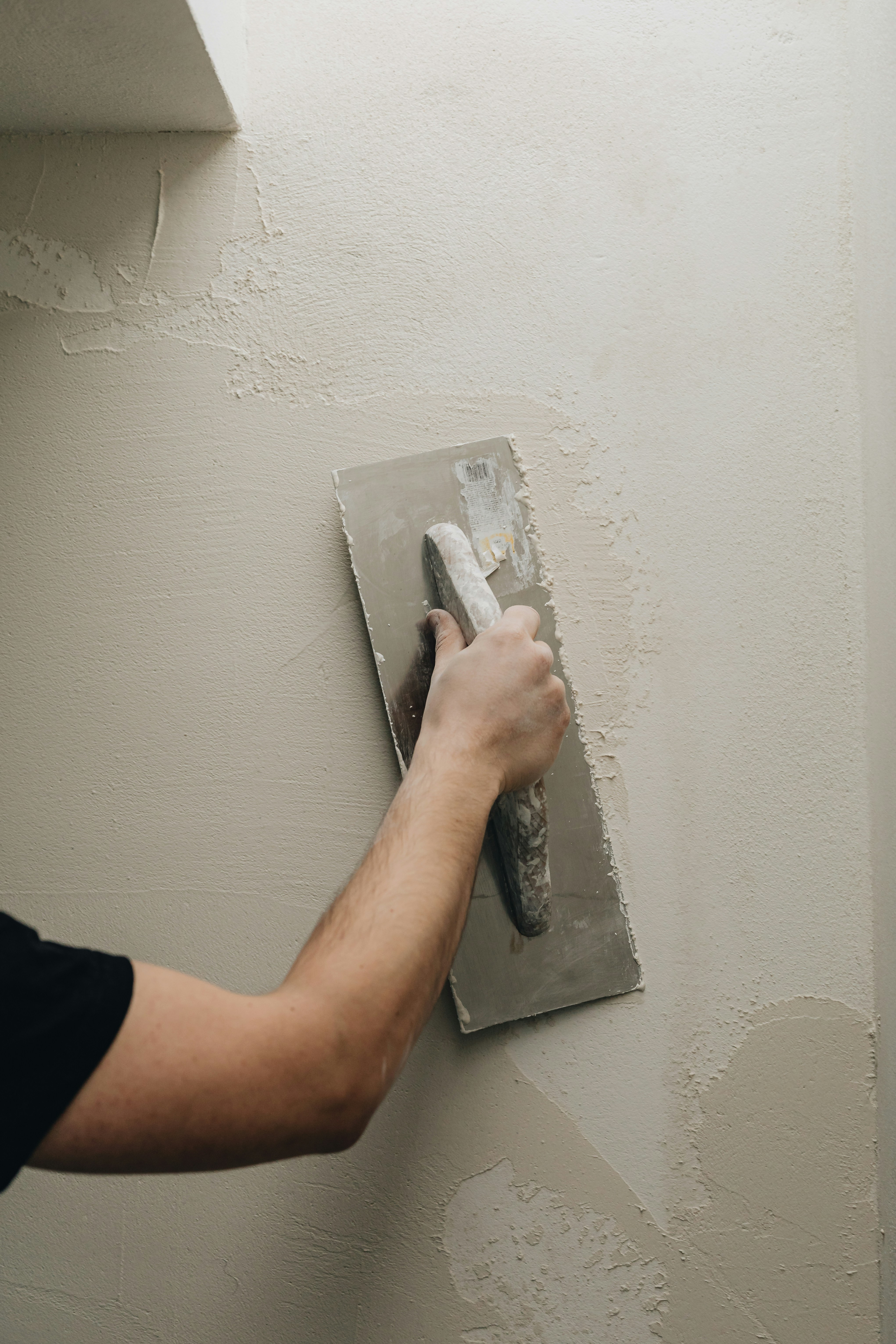 Plasterer finishing an interior wall with a trowel